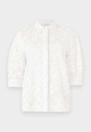 White embroidered blouse with a collared neck, three-quarter sleeves, floral patterns, and button closure down the front.