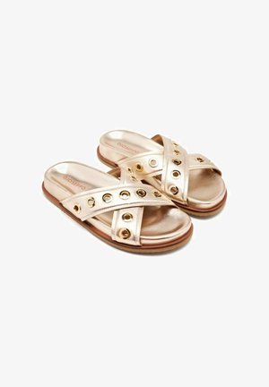 Sandalias de slides metálicas doradas con tiras entrelazadas y recortes circulares, con una plantilla acolchada y una suela de goma marrón.