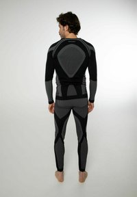 Athletisches Basisschicht-Set in Schwarz und Grau. Bietet ein enganliegendes Design mit gestreiften Mustern und nahtloser Konstruktion. Langärmlig und mit langen Leggings.