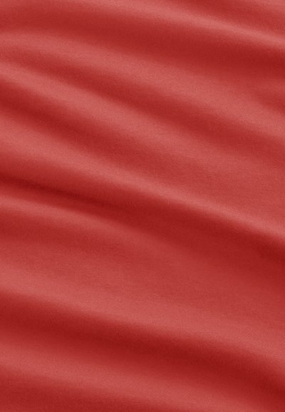 Smooth red fabric with gentle folds and subtle texture, suggesting soft and flexible material.
