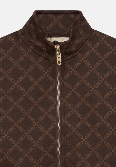 Veste marron avec un motif de logo répétitif, col montant et fermeture éclair dorée avec une finition texturée. Tissu lisse au toucher doux.