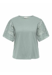 Maglietta verde chiaro con scollatura rotonda e maniche corte in pizzo con texture, caratterizzate da intricati motivi ritagliati. Tessuto morbido e casual.