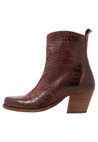 Brun krokodilpräglad läderankelsko med spetsig tå och en staplad träklack. Har en slät finish och dekorativ sömnad.