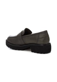 Mocasines de cuero verde oscuro con suela de goma negra gruesa, que presentan una tira ancha en el empeine y un diseño de punta redonda.