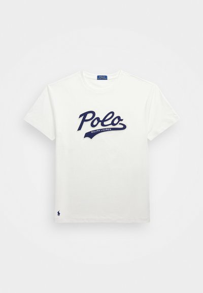 Balts kokvilnas T-krekls ar tumši zilu "Polo" logotipa dizainu un tekstu "Ralph Lauren". Mazs tumši zils zirga logotips apakšējā kreisajā stūrī.