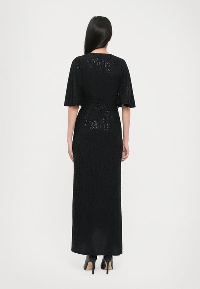 Black, long maxi dress with a textured finish, wide sleeves, and a matching belt. Features a slightly sheer back design.
