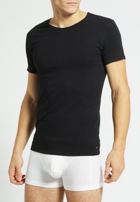Black short-sleeve t-shirt made of cotton, featuring a round neckline and a slim fit, paired with white boxer briefs.