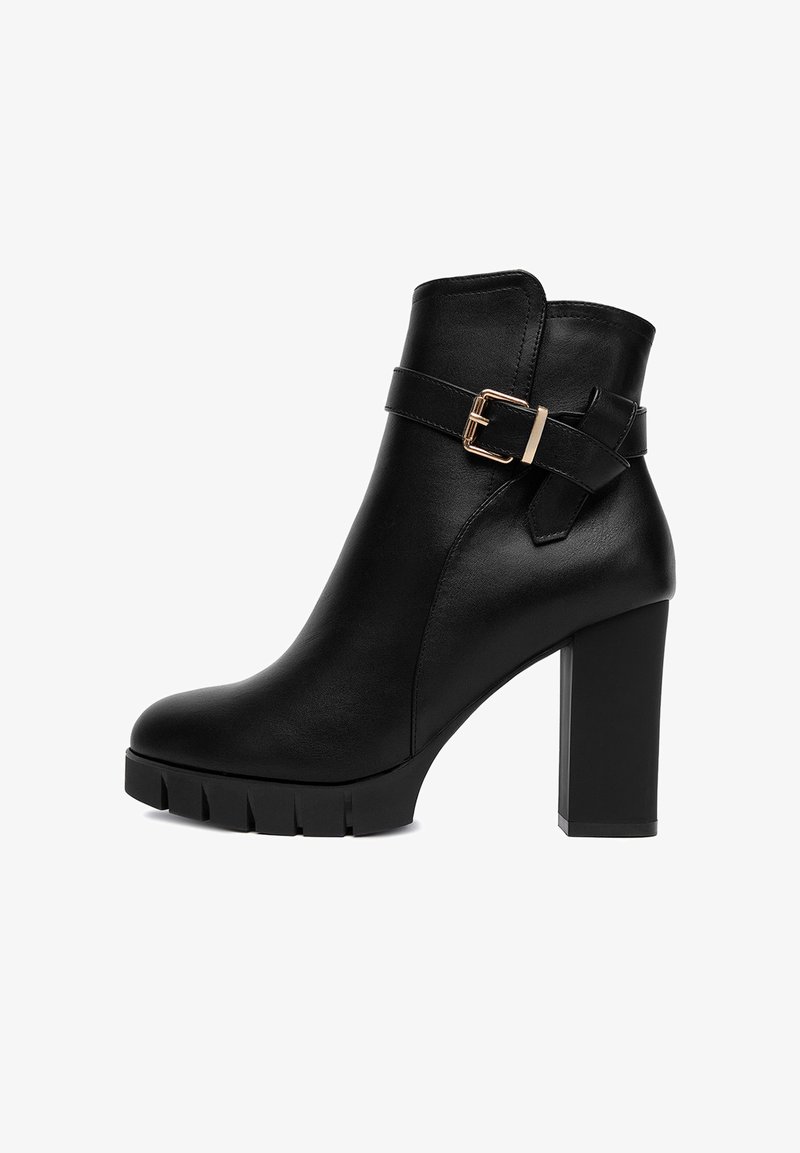 Czarne skórzane botki do kostki z masywnym wysokim obcasem, podeszwą z rowkowanym bieżnikiem oraz dekoracyjnym paskiem z złotą klamrą.