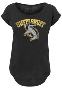 Svart t-skjorte med rund hals og oppbrettede ermer. Har et grått grevlinggrafikk og "HUFFLEPUFF" i gult distressed tekst.