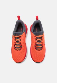 Baskets de sport orange vif avec accents gris, tige en maille, bout rond, lacets plats et semelle rembourrée. Deux languettes pour un enfilage facile.
