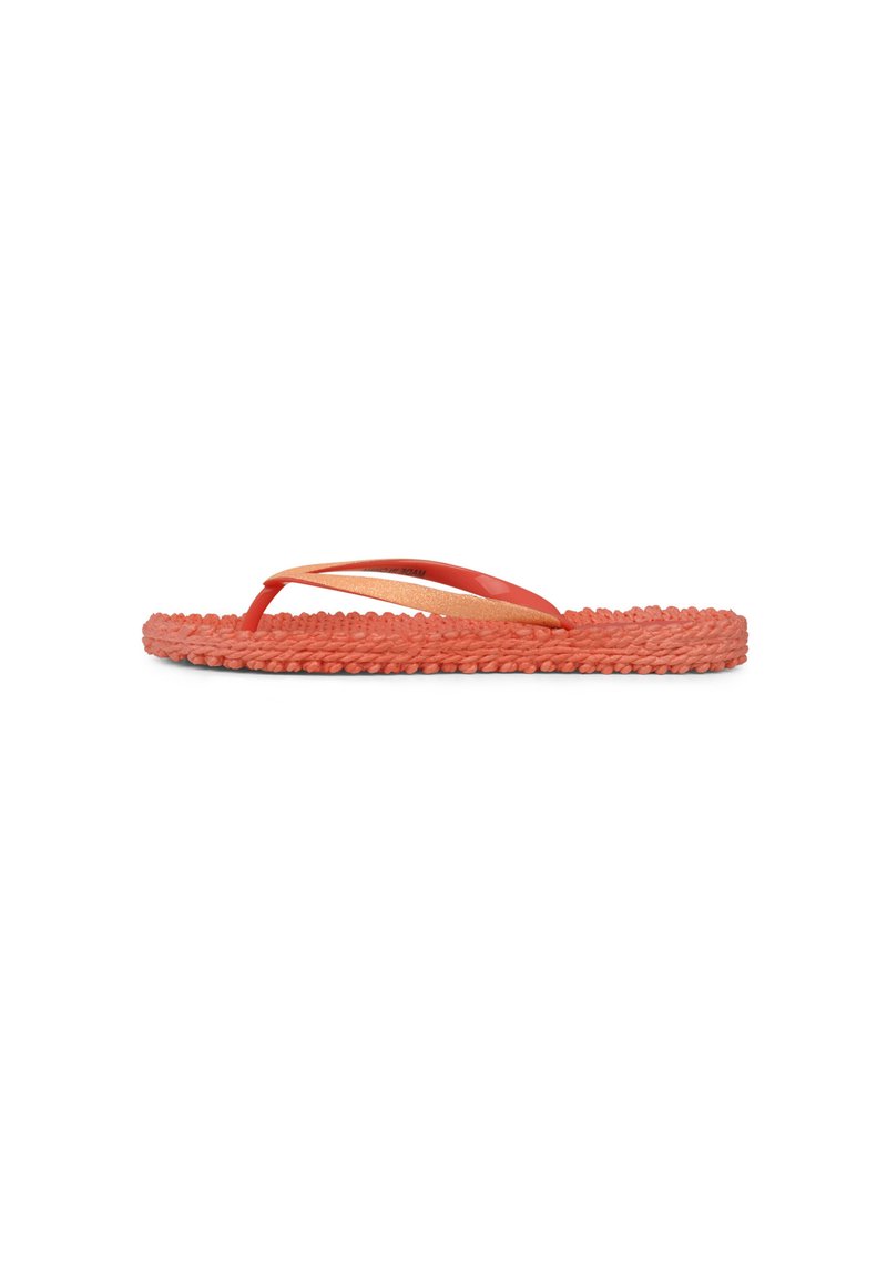 Röd flip-flop med en vävd texturerad sula, tunna gummiband och en något upphöjd kant. Det övre bandet har en subtil metallisk detalj.
