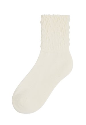Ein Paar socken in cremefarben mit einem strukturierten, gerippten Muster am Bund und einem glatten Körper, hergestellt aus weichem Stoff.