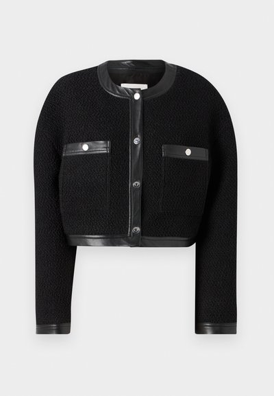 Melnā īsā jakā ar strukturētu audumu, ādas akcentiem un divām priekšējām kabatām. Iezīmējas ar pogu aizdari un apaļu apkakli.