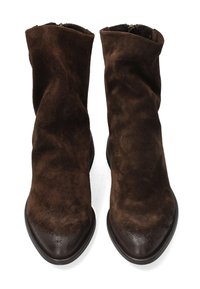 Brązowe zamszowe botki za kostkę o luźnym fasonie, z ostrymi noskami i gładką, ciemnobrązową gumową podeszwą. Posiadają boczny zamek ułatwiający zakładanie.