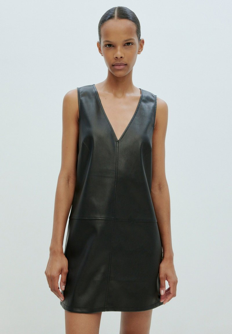 Schwarzes, ärmelloses Lederkleid mit V-Ausschnitt; glatte Textur, minimale Nähte und gerade Silhouette.