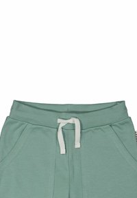 Mynta gröna joggers med ribbad midja, vit snörning och snedställda sidofickor. Mjuk bomullsblandning med en slät textur.