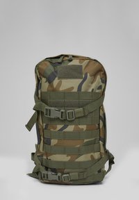 Taktinė kuprinė su kamufliažo raštu, keliais horizontaliais dirželiais ir plastikiniais sagties užsegimais, paprastame pilkame fone.