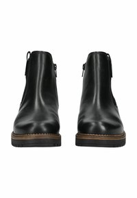 Botas de tobillo de cuero negro con un acabado suave, que presentan un tacón bajo, cremalleras laterales y una suela marrón contrastante con un borde texturizado.