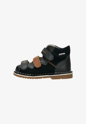 Scarpa alta per bambino piccolo in nero e marrone con tre cinturini in Velcro e suola in gomma beige, dettagli cuciti lungo i bordi.