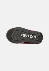 Svart gummiyttersåle med dyp mønster og "SOREL"-logo, med rosa øvre kant. Designet fremhever grep og holdbarhet.