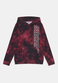 Hoodie tie-dye rouge et noir avec poche kangourou, présente le texte blanc "ABERCROMBIE" verticalement sur le côté gauche, en matériau coton.