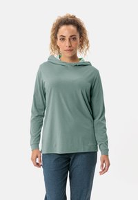 Hellgrünes, kapuzenförmiges Langarmshirt mit lockerer Passform und dezentem Logo-Stick. Weicher, glatter Stoff mit leicht strukturierten Oberflächen.
