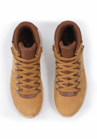 Stivali da trekking in suede marrone con dettagli in pelle marrone, occhielli metallici e lacci gialli. Con una parte superiore imbottita e una suola in gomma bianca.
