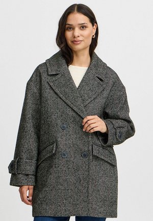 Grijs herringbone wollen jas met een brede revers, dubbelgeknoopte knopen en opgestikte zakken. De stof heeft een gestructureerde afwerking.