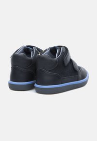 Zwarte leren en suede high-top schoenen met blauwe accenten, uitgerust met klittenbandsluiting en een gestructureerd achterpaneel.