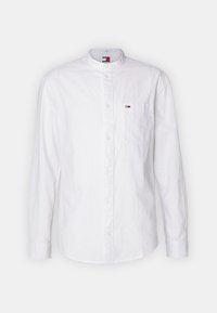 Camisa blanca de botones con cuello de banda, mangas largas y un bolsillo en el pecho izquierdo que presenta un pequeño logotipo. Tejido texturizado con un acabado nítido.