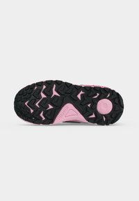 Semelle de chaussure de sport noire et rose avec un motif de crampons triangulaires robustes, vue de dessous, comprenant du texte et des indications de taille.
