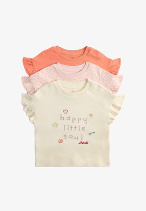 Tre baby kortærmede bluser med flæseærmer i creme, pink med små prikker og koral; den cremefarvede bluse har broderet "happy little soul".