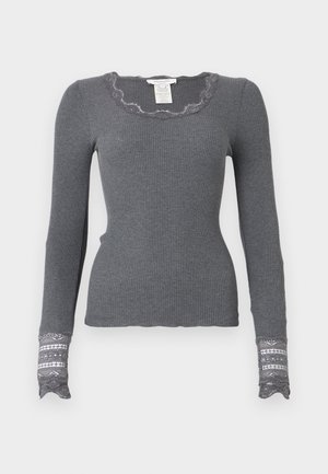 Grå långärmad ribbad topp med vågig halsringning och spetsprydda ärmslut som har ett texturerat mönster.