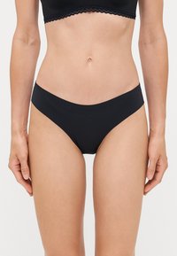Schwarze Bikiniunterteile mit glatter Textur und niedrigem Schnitt. Bietet minimale Abdeckung mit nahtlosen Kanten und ohne sichtbare Beschläge.