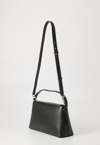 Borsa a tracolla in pelle nera con una forma strutturata, tracolla regolabile e manico superiore. Presenta un'accattivante accentuazione diagonale cucita sul davanti.