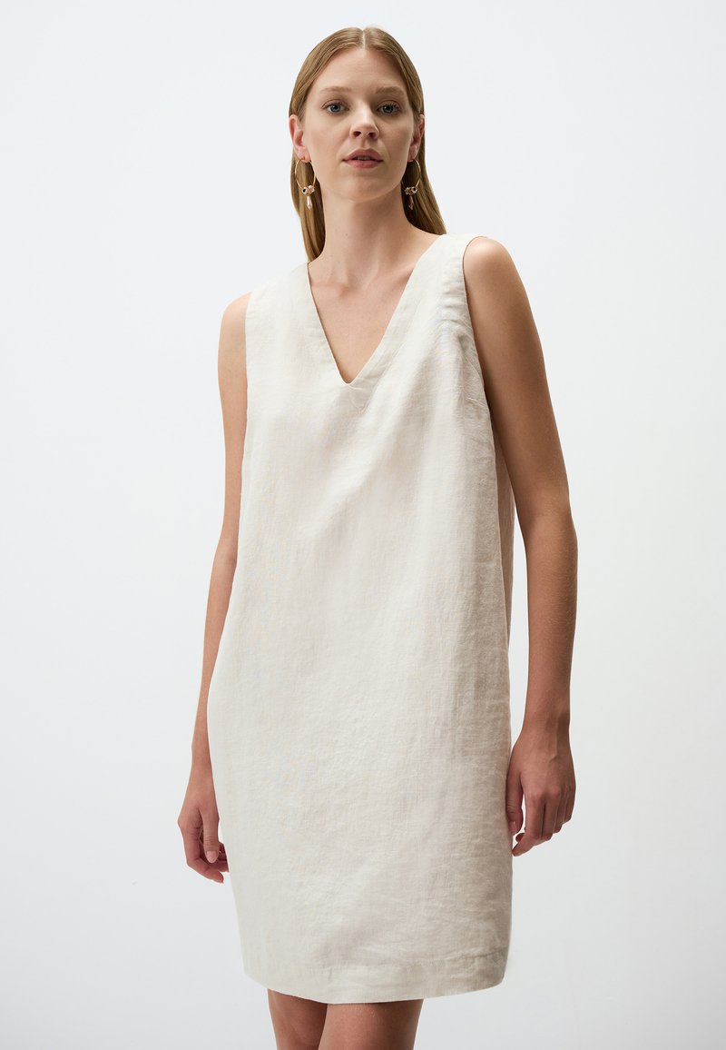 Ärmelloses Leinenkleid mit V-Ausschnitt, hellbeige Farbe, lockere Passform, mittellange Länge bis zur Oberschenkelmitte und einem glatten, strukturierten Stoff.