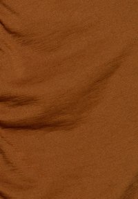Brązowa, teksturowana tkanina z delikatnym, prążkowanym wzorem, ukazująca subtelne różnice w odcieniu i odbiciu światła. Miękki, elastyczny materiał.