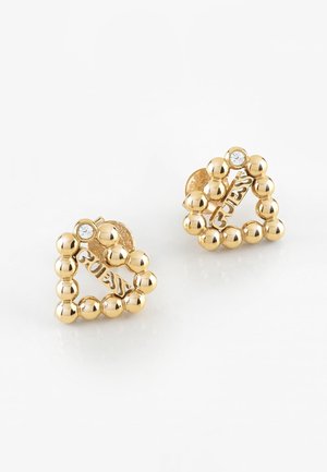 Boucles d'oreilles clous triangulaires dorées composées de perles rondes avec un petit cristal et le logo « GUESS » à l'intérieur de chaque triangle.