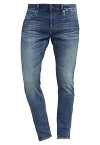 Slimfit blå jeans i denim med en blekt design, fem fickor samt standardknapp och dragkedja som stängning.