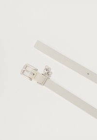 Cinto de couro branco com fivela metálica prateada, apresentando um charme decorativo. Textura suave, design minimalista e comprimento ajustável.