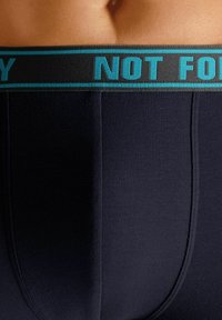Navy fabric boxer briefs with a black waistband featuring turquoise text "NOT FOR YOU." Soft texture with simple design and minimal seams.