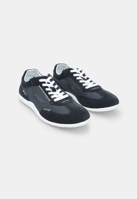 Sneakers neri in camoscio con lacci bianchi, tessuto testurizzato e suole in gomma con un motivo ondulato per una migliore aderenza. Design elegante a taglio basso.