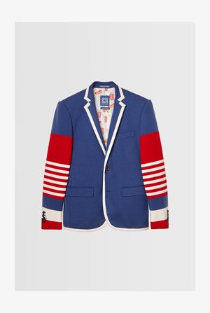 Šareno modro blejzer s rdečimi poudarkom na rokavih in belimi črtastimi detajli, ki ima kontrastne bele obrobe in igrivo podlogo z vzorcem hrane.