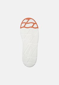 White shoe sole with textured pattern; orange accent at the heel. Features brand logo and size '42' embossed on the surface.