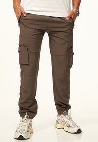 Braune Cargo-Hosen mit mehreren Seitentaschen, einer schmal zulaufenden Passform, elastischen Bündchen und einem glatten Stoff mit leichtem Glanz.