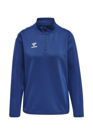 Blå sportstrøje med lange ærmer, kvart lynlås, høj krave, hvid hummel-logo på brystet og hvide chevron-striber på skuldrene.