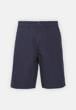Marineblauwe katoenen shorts met een knoopsluiting, vlakke voorkant en zijzakken; middellang met een soepele, lichte textuur.