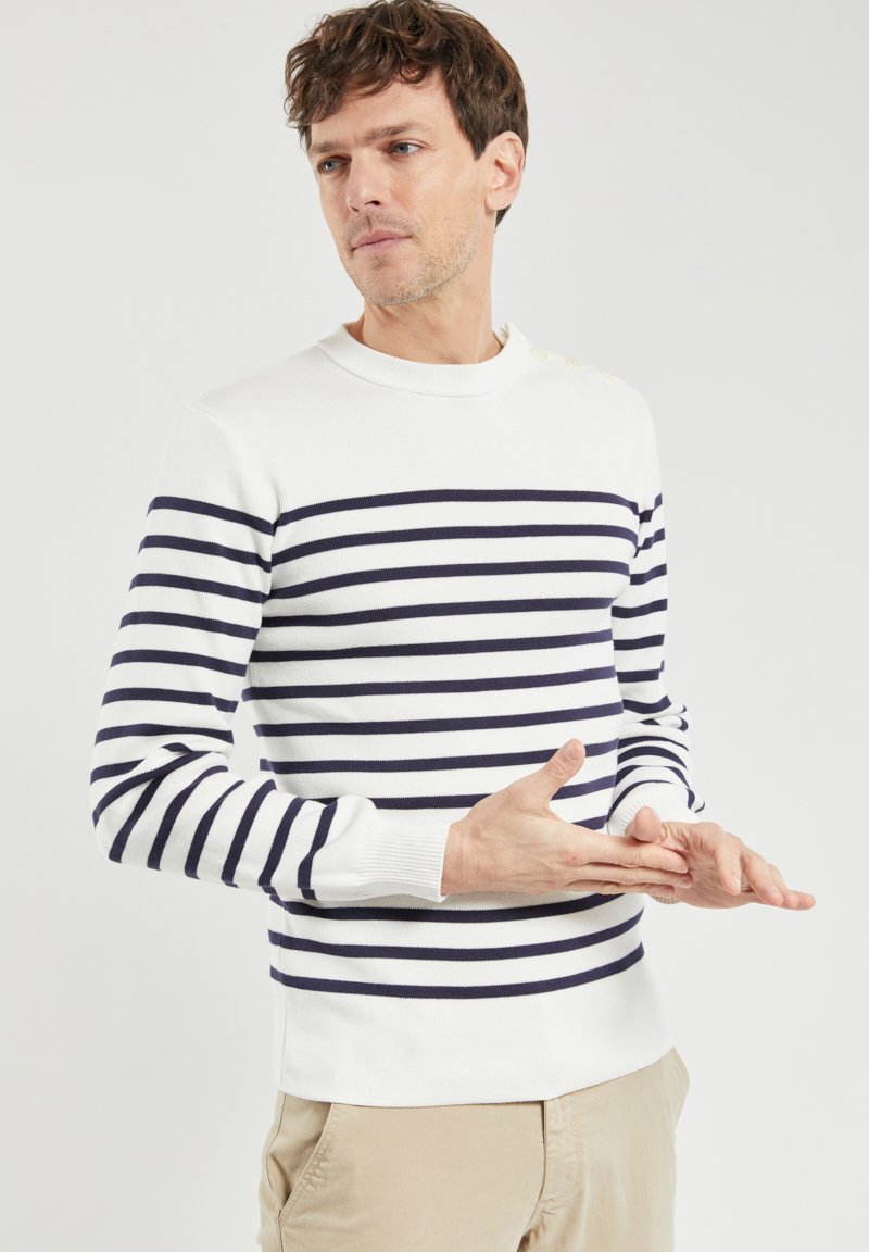 Maglione a righe realizzato in tessuto bianco con strisce orizzontali blu navy, dotato di collo a giro e polsini a costine. Texture liscia, design casual.