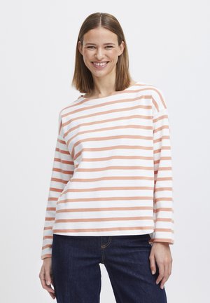 Gestreepte lange mouw top in het wit met perzikstrepen, met een ruime halslijn en een ontspannen pasvorm. In combinatie met donkerblauwe jeans. Zachte textuur.