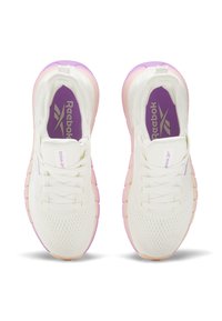 Zapatillas deportivas blancas con parte superior de malla, detalles en púrpura, suela degradada en rosa y un cuello acolchado. Marca visible en la lengüeta.